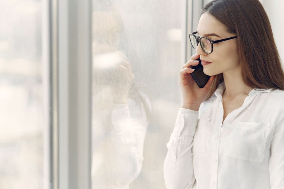 Mujer hablando por telefono mirando a una ventana.
